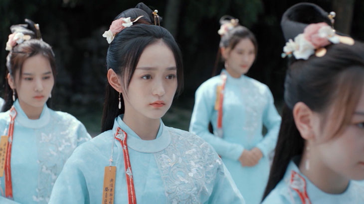 Cảnh phim Khúc Liên Hoa (The Story of Qinglan) với hình ảnh nữ nhân vật trong trang phục cổ trang xanh nhạt giữa khung cảnh trang nghiêm.