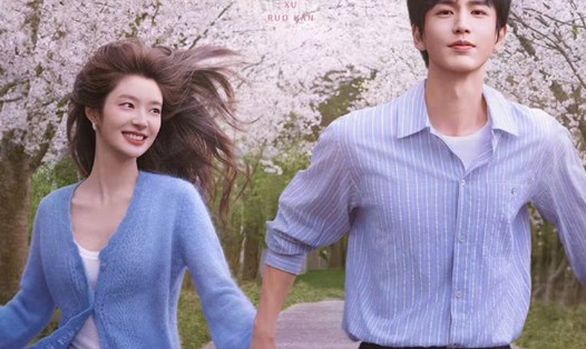 Hình ảnh cặp đôi chính trong phim Trường Lăng Hách nắm tay nhau chạy giữa hàng cây hoa anh đào nở rộ.