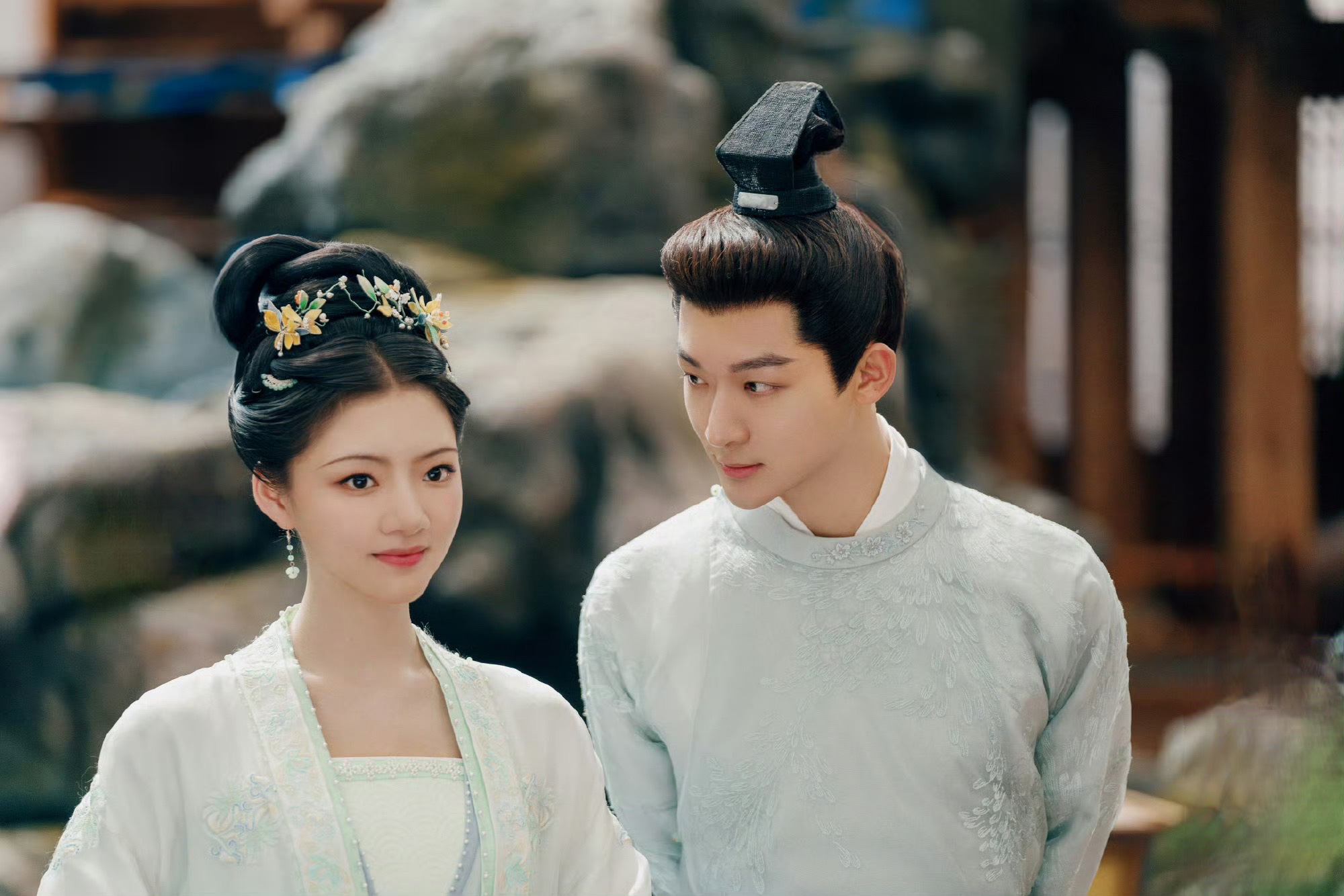 Cảnh phim Cẩm Tư An Ninh – The Rise of Ning với hình ảnh nam – nữ chính đứng cạnh nhau trong trang phục cổ trang trắng, ánh nhìn dịu dàng.