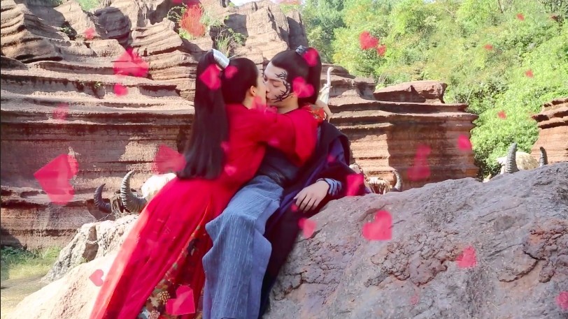 Cảnh hôn ngọt ngào trong phim Chiêu Dao (The Legends) khi nữ chính chủ động ôm hôn nam chính giữa khung cảnh núi đá hoang dã, cánh hoa đỏ bay lả tả.
